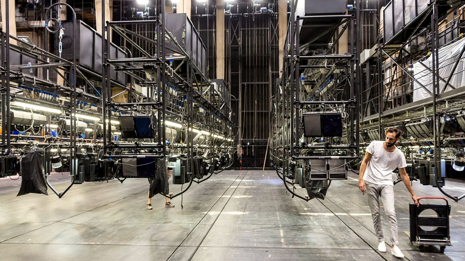 A dancer crossing an empty stage before the set is built