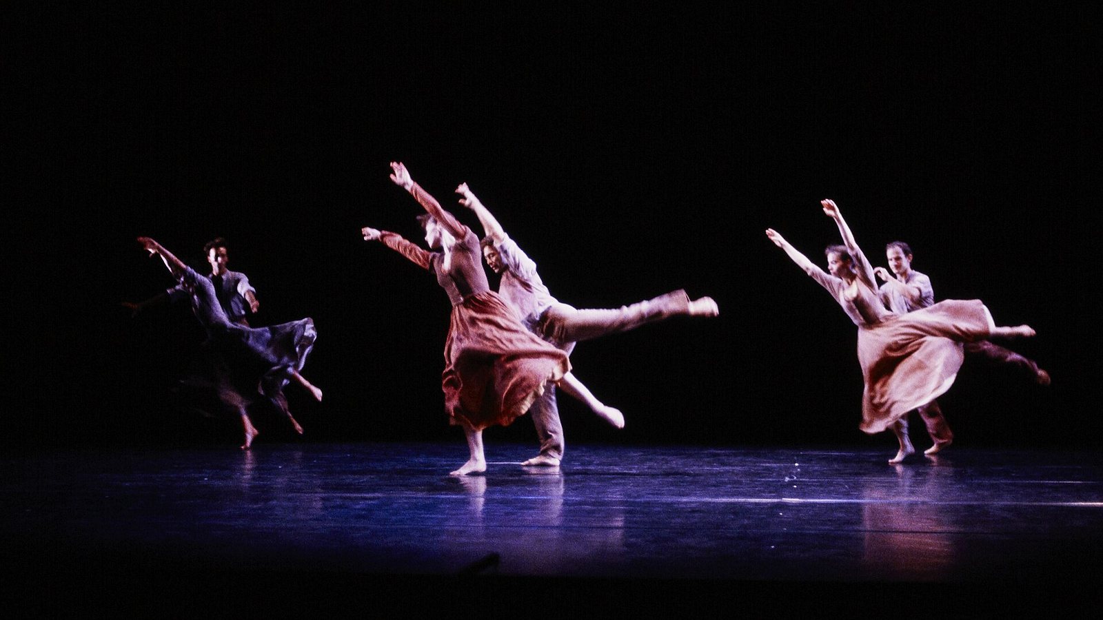An ensemble of dancers in pale costumes