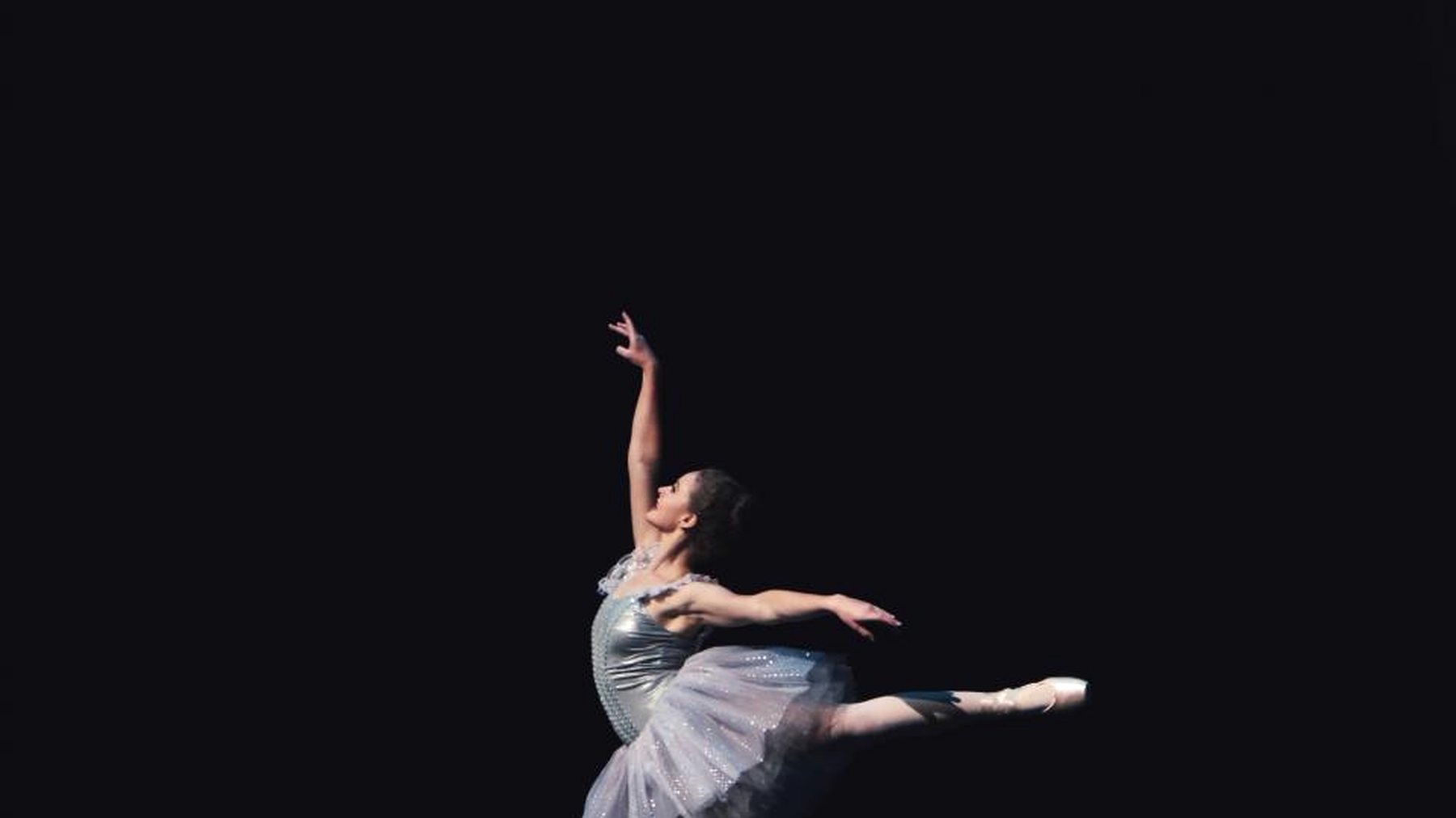 A tiny figure alone on a vast black stage