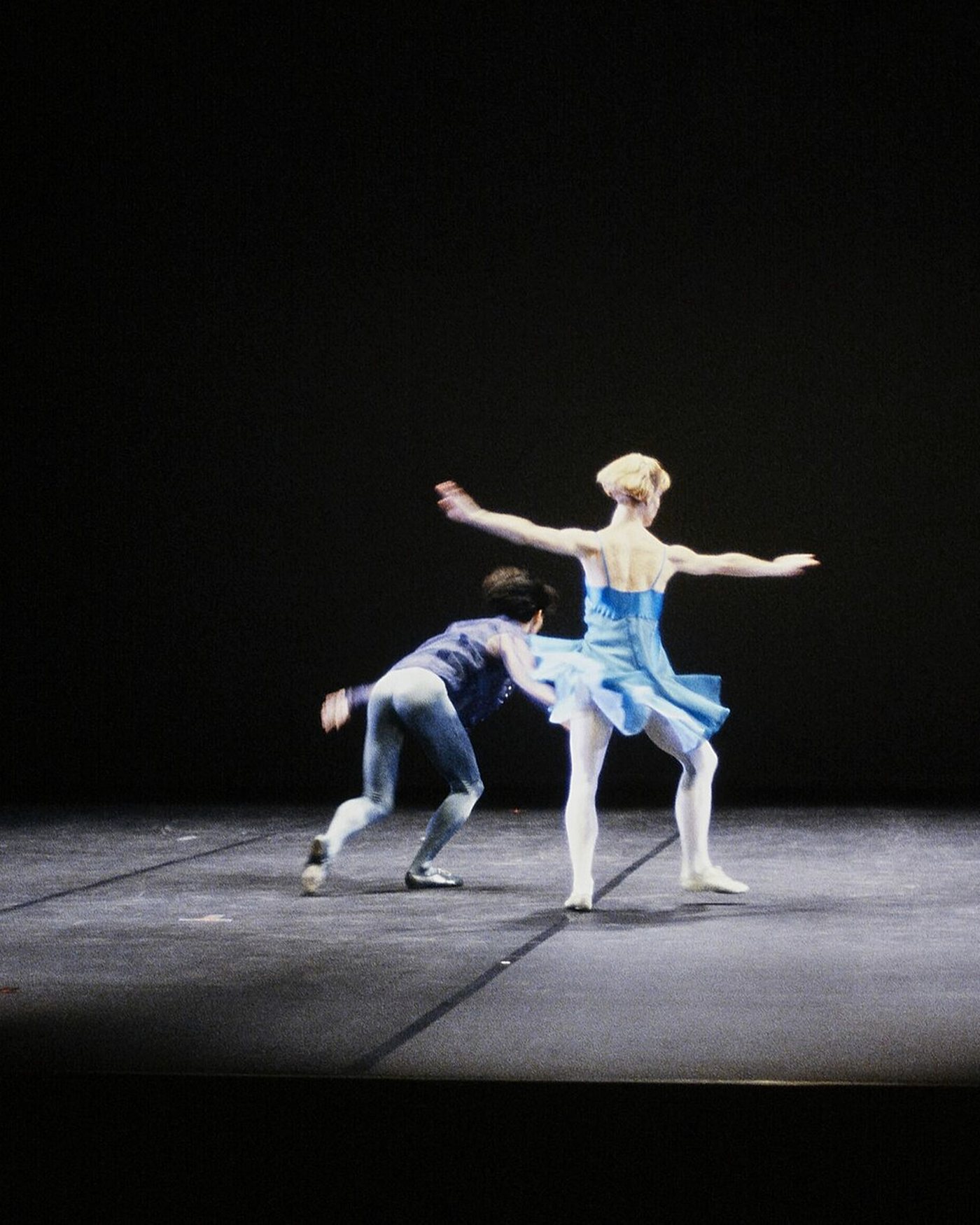 A lone dancer on a blue-lit stage