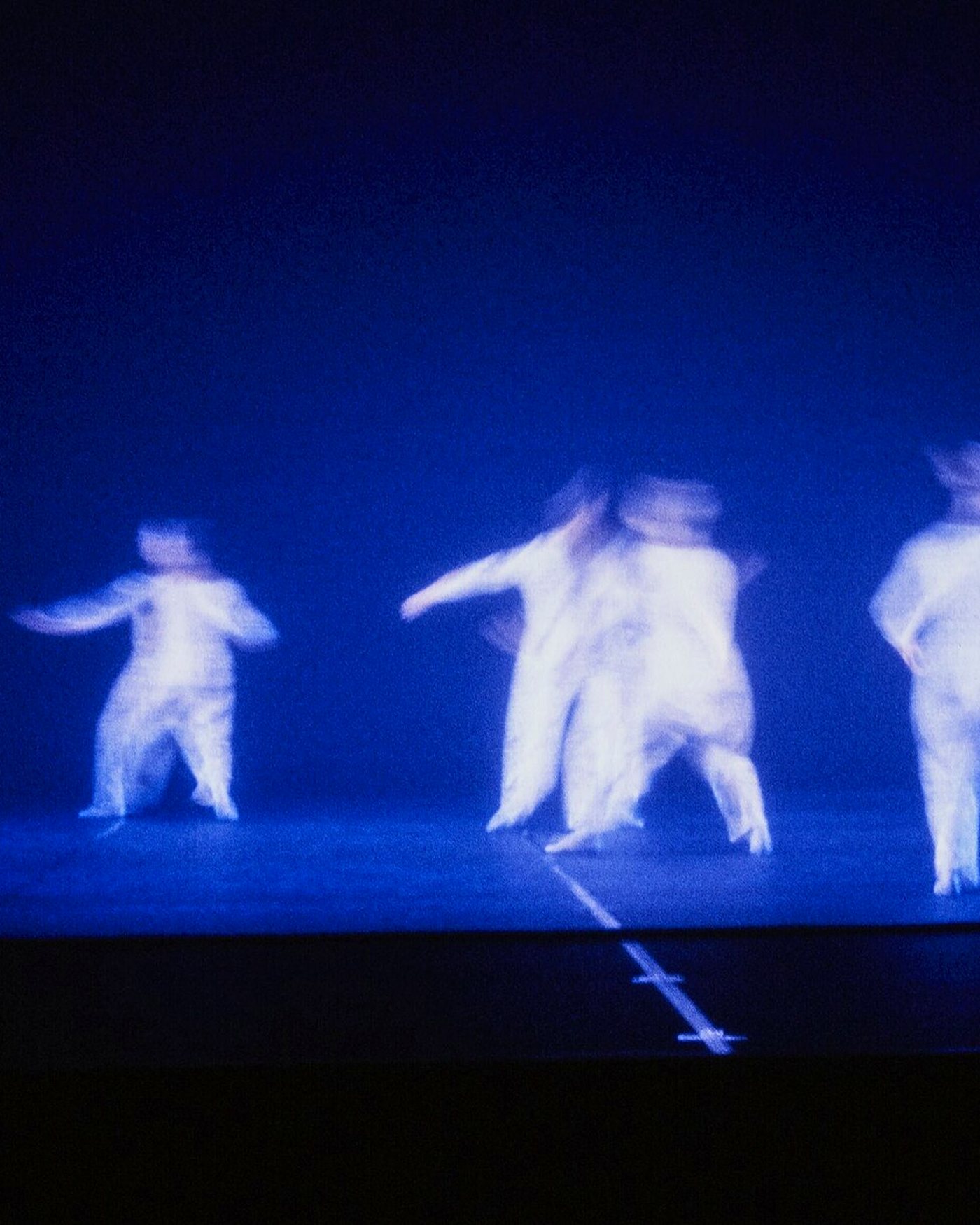 Blurred dancers in long exposure against deep blue