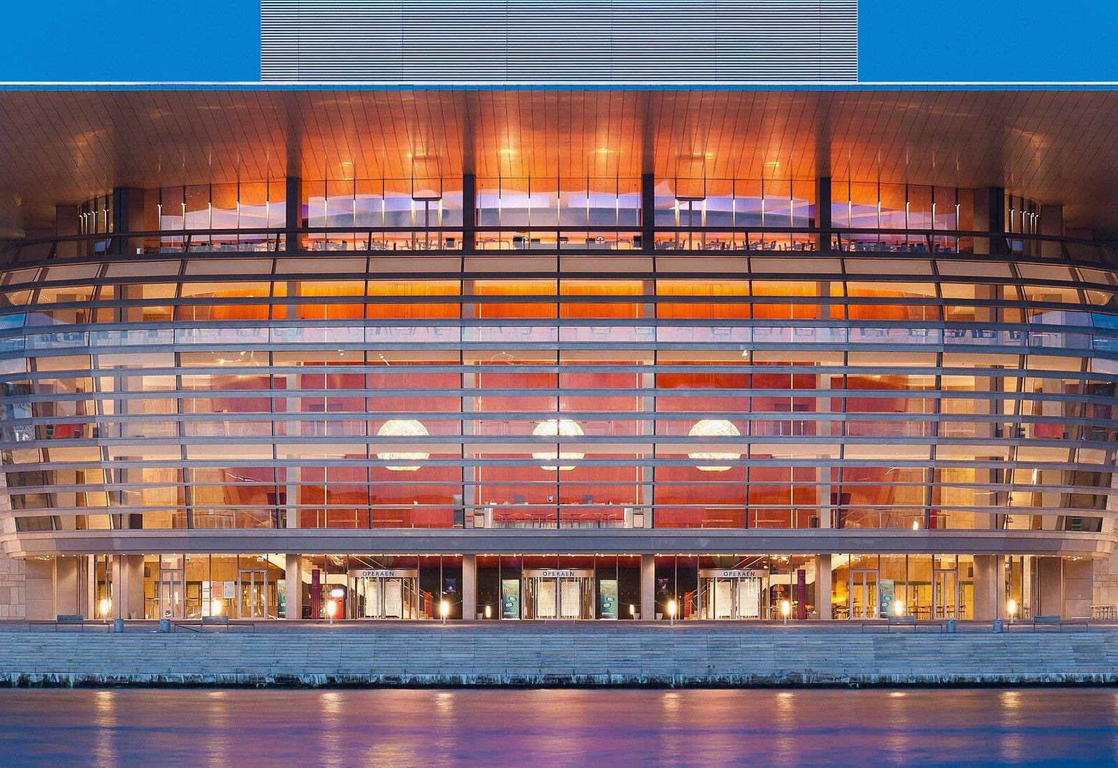 The Copenhagen Opera House lit at night across the water